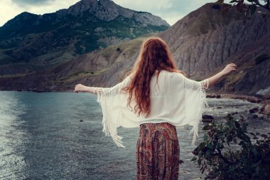 Güneş ışığı altında sahilde poz beyaz tığ işi mayo giyen güzel boho tarz modeli