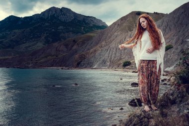 Güneş ışığı altında sahilde poz beyaz tığ işi mayo giyen güzel boho tarz modeli