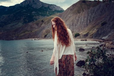 Güneş ışığı altında sahilde poz beyaz tığ işi mayo giyen güzel boho tarz modeli