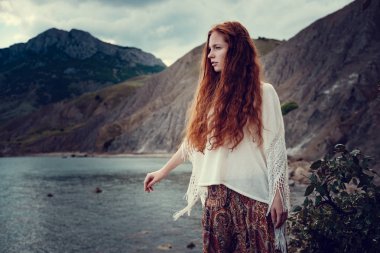 Güneş ışığı altında sahilde poz beyaz tığ işi mayo giyen güzel boho tarz modeli