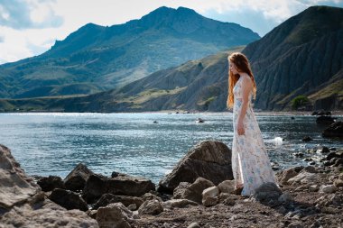 Güzel boho tarz modeli Güneş ışığı altında sahilde poz beyaz elbise