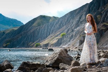 Güzel boho tarz modeli Güneş ışığı altında sahilde poz beyaz elbise