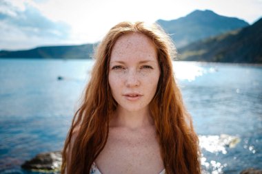 Güzel boho tarz modeli Güneş ışığı altında sahilde poz beyaz elbise