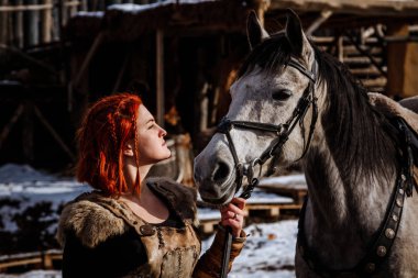 Savaş için onu hazırlamak bir sadık atı ile Kızıl saçlı kadın