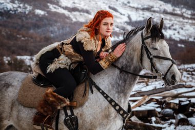 At ve zırh Kızıl saçlı güzel kız. Bir Viking kadındır. Fantezi
