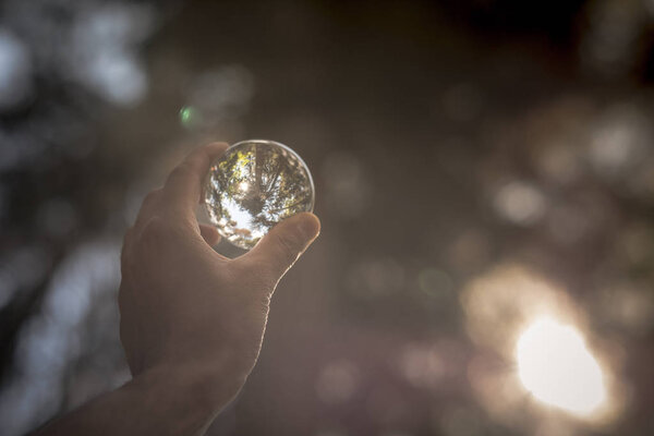 Концепция и идея путешествия. Снежные вершины Альп видны через стеклянный шар, держащийся за руку
