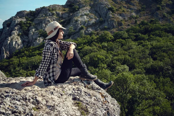 Kvinnan rest med ryggsäck holding hatt och titta på fantastiska berg och skog, wanderlust resor koncept, utrymme för text, atmosfäriskt episka ögonblick — Stockfoto