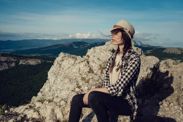 Kvinnan rest med ryggsäck holding hatt och titta på fantastiska berg och skog, wanderlust resor koncept, utrymme för text, atmosfäriskt episka ögonblick — Stockfoto