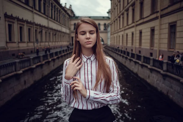 Una joven pelirroja con traje de negocios camina por un hermoso casco antiguo. San Petersburgo —  Fotos de Stock