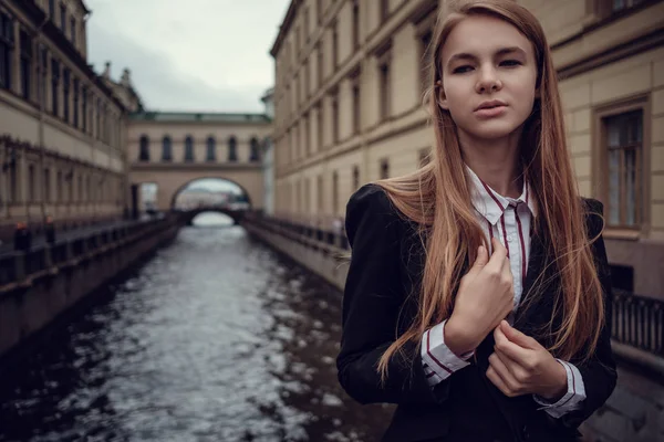 Ein junges rothaariges Mädchen im Businessanzug spaziert durch eine wunderschöne Altstadt. st.petersburg — Stockfoto