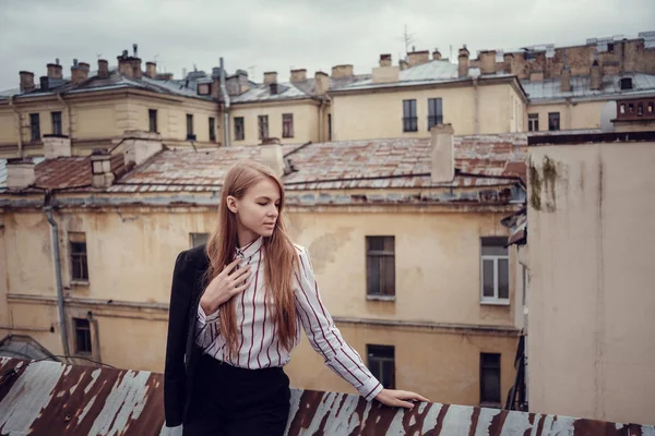 İş takım elbiseli kızıl saçlı bir kız güzel bir eski şehir yürüyor. St.Petersburg