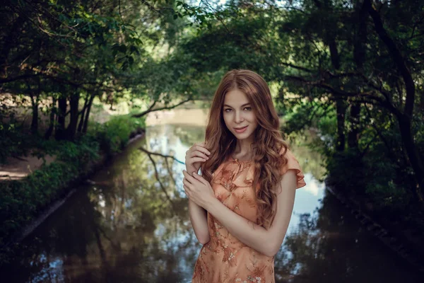 Genç kadın, yaz yeşil Park, yeşil bir arka plana dayanır bırakır. Güzel kıvırcık saçlı çalışan kız — Stok fotoğraf
