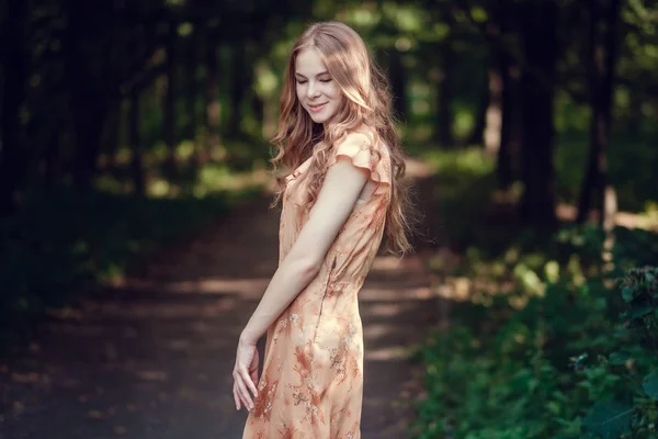 Young woman, against background of summer green park, green leaves. Running girl with beautiful curly hair — Stock Photo, Image