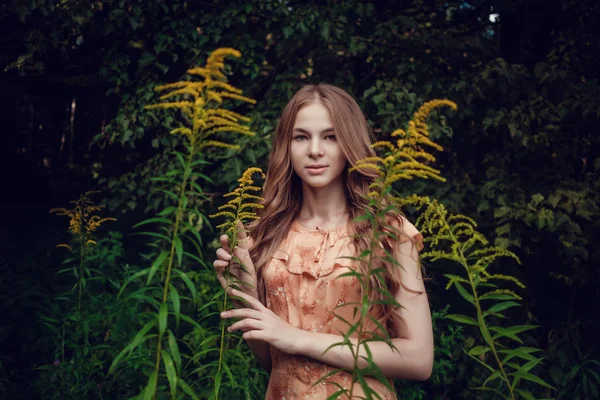 Mladá žena, pozadí letní zelený park, zelené listy. Běžící dívka s krásné kudrnaté vlasy — Stock fotografie