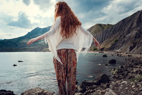 Güneş ışığı altında sahilde poz beyaz tığ işi mayo giyen güzel boho tarz modeli