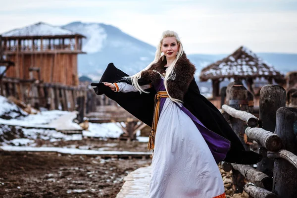 Beautiful young woman holding a viking with blond hair. Image of Historical figure — Stock Photo, Image