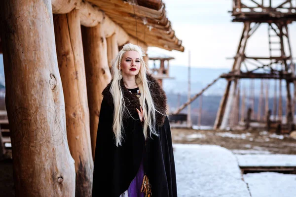 Beautiful young woman holding a viking with blond hair. Image of Historical figure — Stock Photo, Image