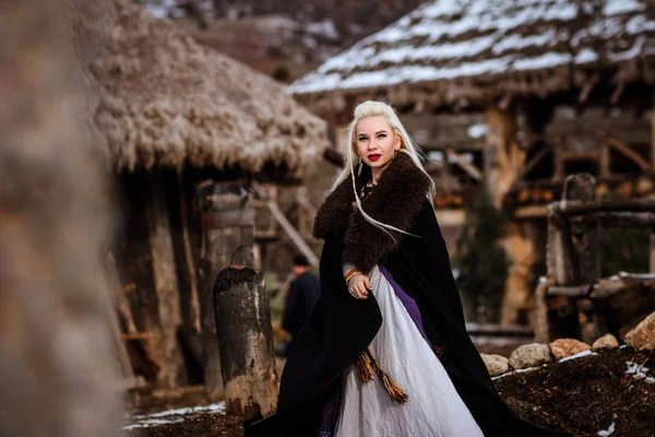 Beautiful young woman holding a viking with blond hair. Image of Historical figure — Stock Photo, Image