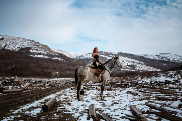 Vacker flicka på häst och med rött hår i rustning. Kvinnan är en Viking. Fantasy — Stockfoto