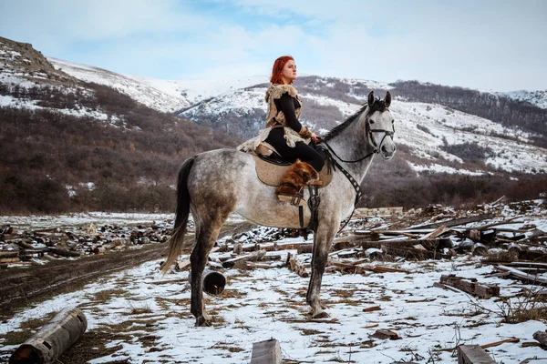 Vacker flicka på häst och med rött hår i rustning. Kvinnan är en Viking. Fantasy — Stockfoto