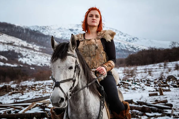 Beautiful girl on horse and with red hair in armor. Woman is a Viking. Fantasy — Stock Photo, Image