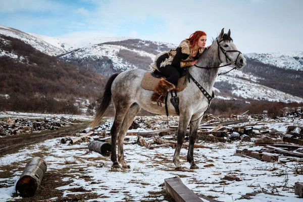 Vacker flicka på häst och med rött hår i rustning. Kvinnan är en Viking. Fantasy — Stockfoto