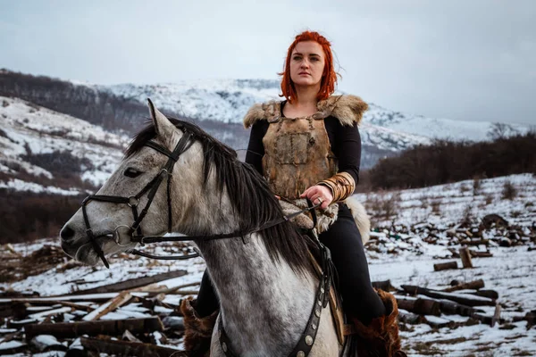 Beautiful girl on horse and with red hair in armor. Woman is a Viking. Fantasy — Stock Photo, Image