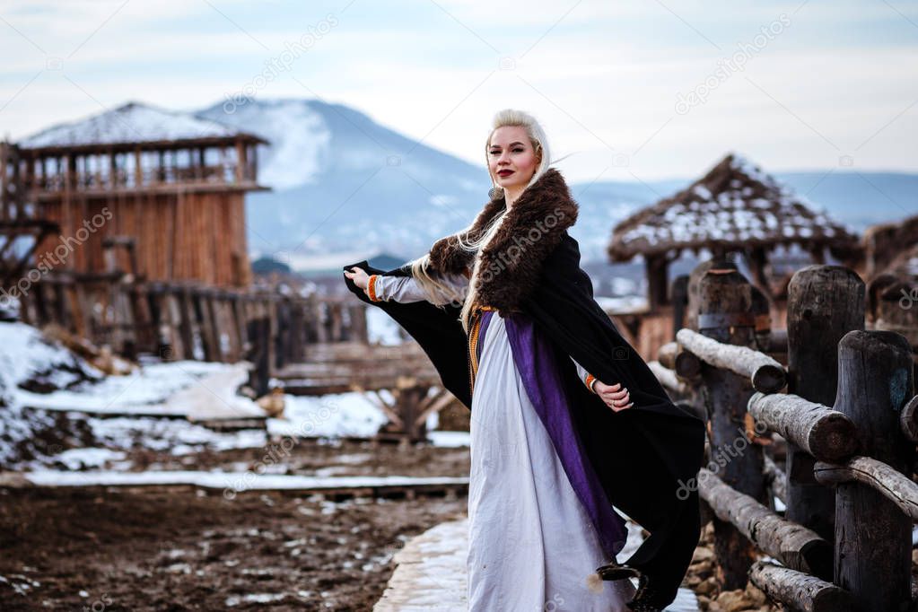 Beautiful young woman holding a viking with blond hair. Image of Historical figure