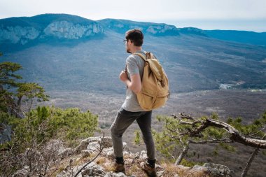 Genç hipster adam bahar dağlarda,