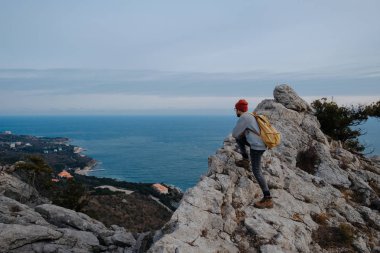 Sırt çantalı bir adam dağda yürüyüş yapıyor.