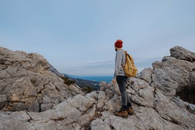 Sırt çantalı bir adam dağda yürüyüş yapıyor.