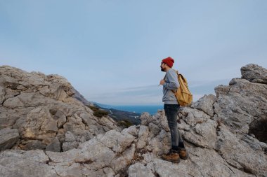 Sırt çantalı bir adam dağda yürüyüş yapıyor.