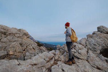 Sırt çantalı bir adam dağda yürüyüş yapıyor.