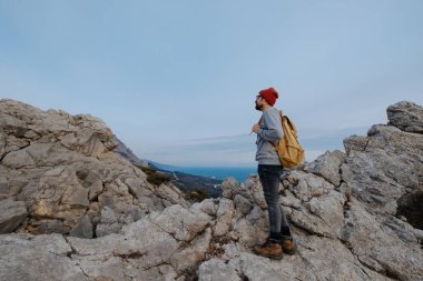 Sırt çantalı bir adam dağda yürüyüş yapıyor.
