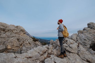 Sırt çantalı bir adam dağda yürüyüş yapıyor.