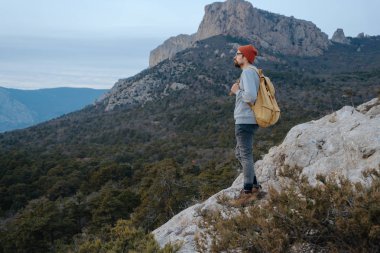 Sırt çantalı bir adam dağda yürüyüş yapıyor.