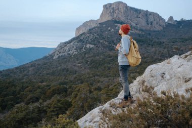 Sırt çantalı bir adam dağda yürüyüş yapıyor.