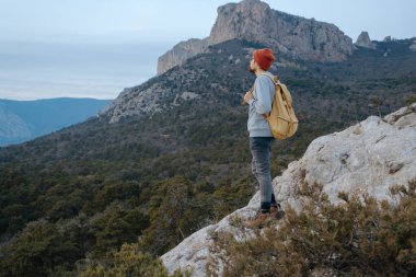 Sırt çantalı bir adam dağda yürüyüş yapıyor.
