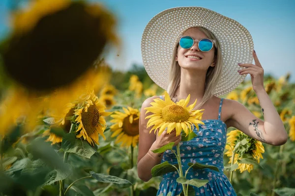Krásná sladká sexy dívka v modrých šatech na poli slunečnic, s úsměvem a krásný úsměv, veselá dívka, styl, životní styl, ideální pro reklamní a fotografické slunce svítí jasné a šťavnaté — Stock fotografie