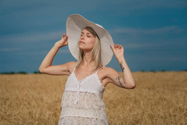 Natureza, férias de verão, férias e conceito de pessoas - cara de mulher sorridente feliz ou adolescente n em chapéu no campo de cereais — Fotografia de Stock