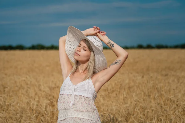 Nature, vacances d'été, vacances et concept de personnes - visage de femme souriante heureuse ou adolescente n dans le chapeau sur le champ de céréales — Photo