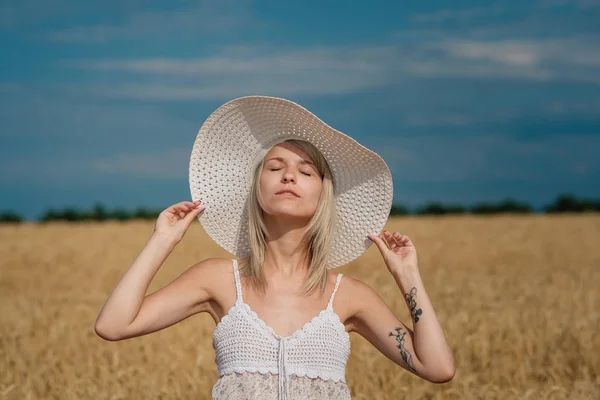 Naturaleza, vacaciones de verano, vacaciones y el concepto de la gente - cara de mujer sonriente feliz o adolescente n sombrero en el campo de cereales —  Fotos de Stock