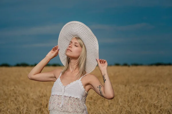 Příroda, letní prázdniny, dovolené a lidé koncept - plocha šťastná usmívající se žena nebo n dospívající dívka v klobouku na obilné pole — Stock fotografie