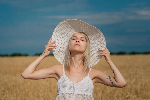 Natureza, férias de verão, férias e conceito de pessoas - cara de mulher sorridente feliz ou adolescente n em chapéu no campo de cereais — Fotografia de Stock