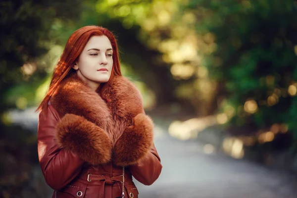 Hermosa joven pelirroja está caminando en el parque de otoño —  Fotos de Stock