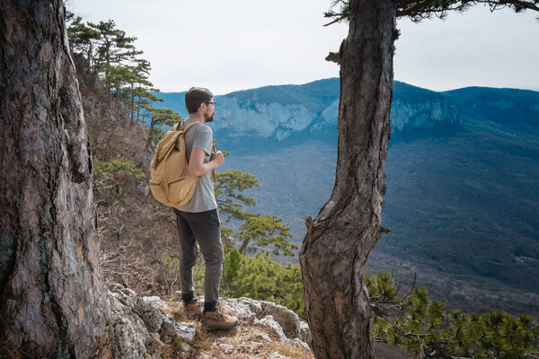 молодой хипстер в весенних горах
