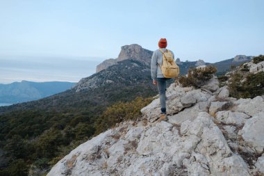 Sırt çantalı bir adam dağda yürüyüş yapıyor.