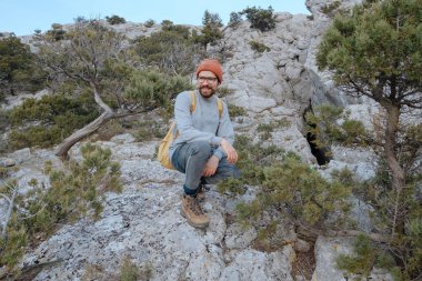 Sırt çantalı bir adam dağda yürüyüş yapıyor.