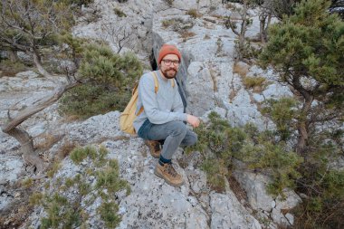 Sırt çantalı bir adam dağda yürüyüş yapıyor.