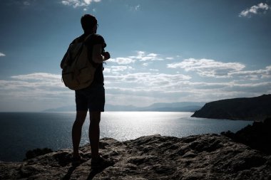 Başarı kavramı. Uzun yürüyüşe çıkan kimse kaldırdı elleriyle bir dağın tepesinde duran ve manzarayı sırt çantası ile